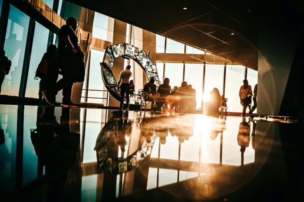 Silhouette of people enjoying sunset views from a modern skyscraper in New York City.